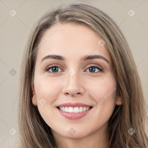 Joyful white young-adult female with long  brown hair and grey eyes