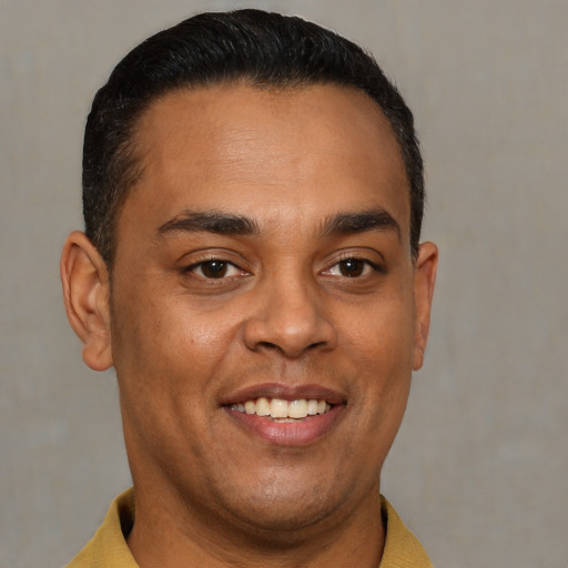 Joyful latino young-adult male with short  brown hair and brown eyes