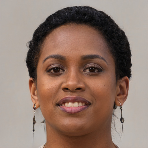 Joyful black young-adult female with long  black hair and brown eyes