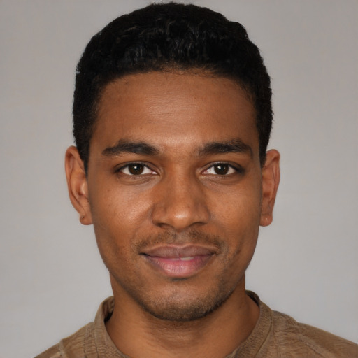 Joyful black young-adult male with short  black hair and brown eyes