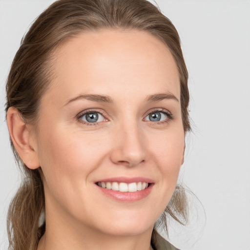 Joyful white young-adult female with long  brown hair and blue eyes