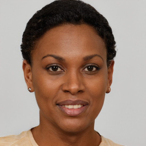 Joyful black young-adult female with short  brown hair and brown eyes