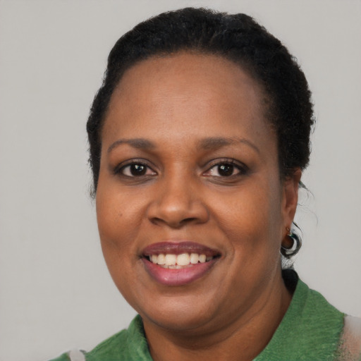 Joyful black adult female with short  black hair and brown eyes
