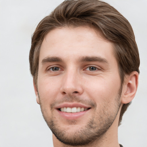 Joyful white young-adult male with short  brown hair and grey eyes