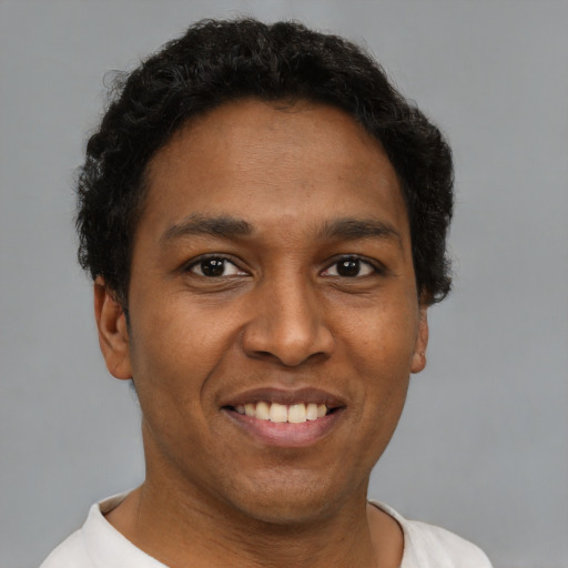 Joyful latino young-adult male with short  brown hair and brown eyes