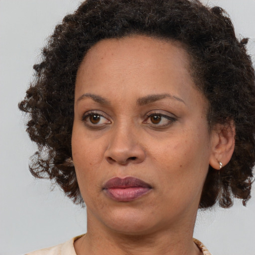 Joyful black adult female with short  brown hair and brown eyes