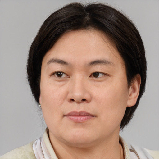 Joyful asian adult female with medium  brown hair and brown eyes