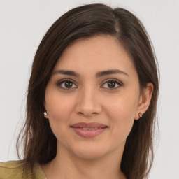 Joyful white young-adult female with long  brown hair and brown eyes