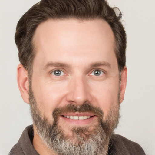 Joyful white adult male with short  brown hair and grey eyes