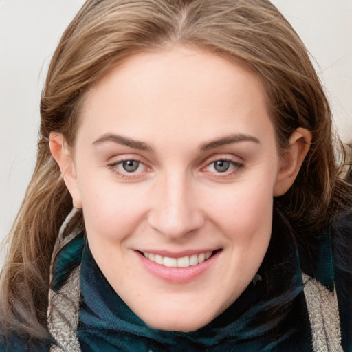 Joyful white young-adult female with long  brown hair and blue eyes