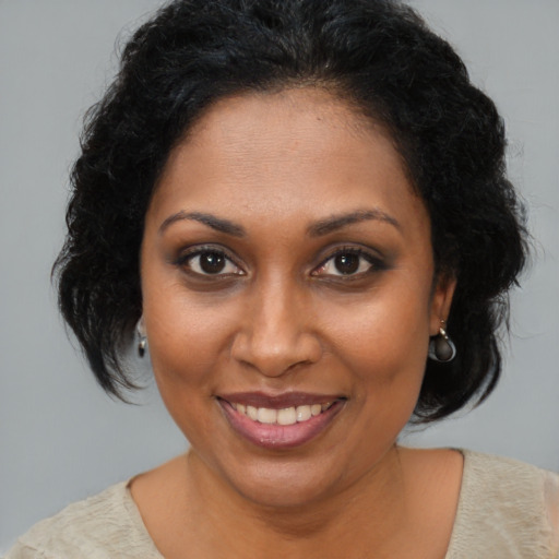 Joyful black young-adult female with medium  brown hair and brown eyes