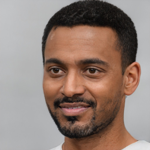 Joyful black young-adult male with short  black hair and brown eyes