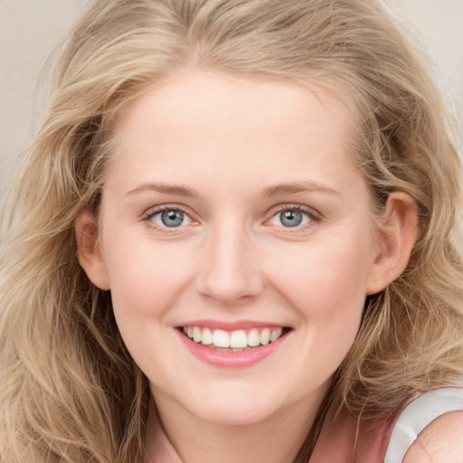 Joyful white young-adult female with long  blond hair and blue eyes