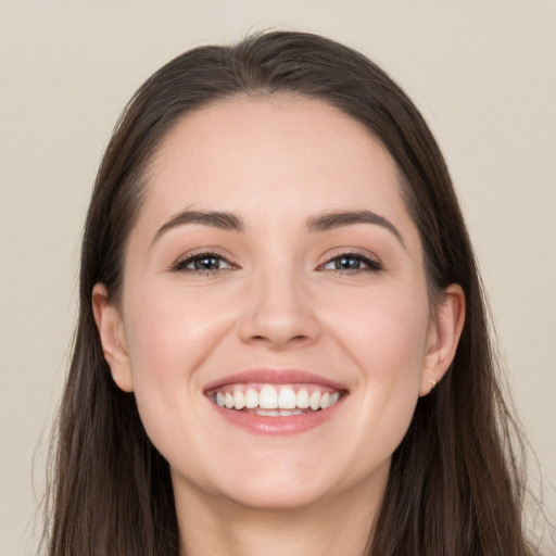 Joyful white young-adult female with long  brown hair and brown eyes