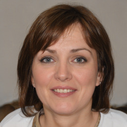 Joyful white young-adult female with medium  brown hair and blue eyes