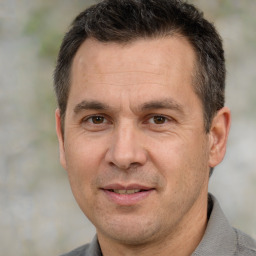 Joyful white adult male with short  brown hair and brown eyes