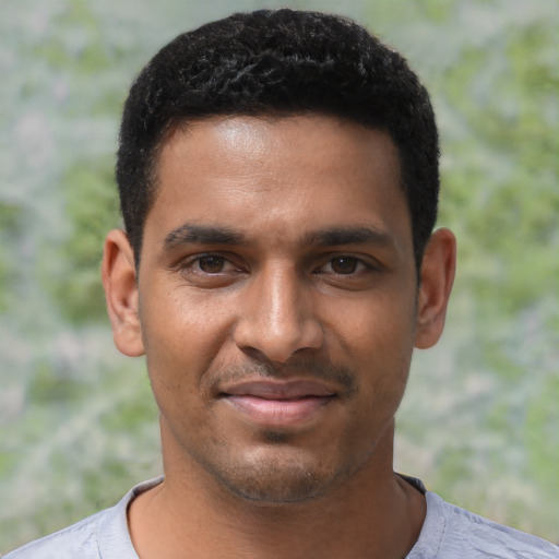 Joyful black young-adult male with short  black hair and brown eyes