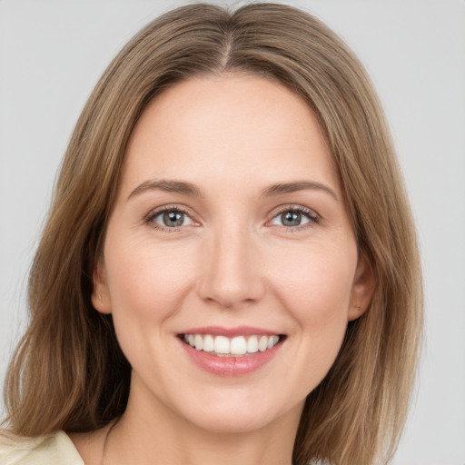 Joyful white young-adult female with medium  brown hair and grey eyes