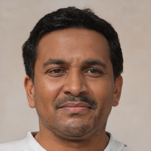 Joyful latino adult male with short  black hair and brown eyes
