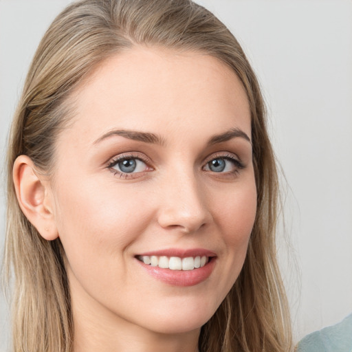 Joyful white young-adult female with long  brown hair and blue eyes