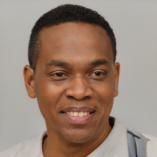 Joyful black young-adult male with short  black hair and brown eyes