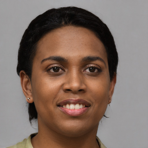 Joyful black young-adult female with short  black hair and brown eyes