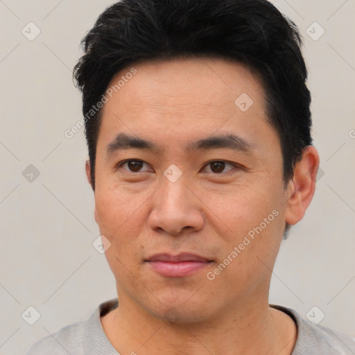 Joyful asian young-adult male with short  black hair and brown eyes