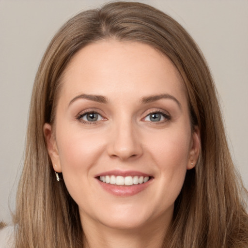 Joyful white young-adult female with long  brown hair and grey eyes