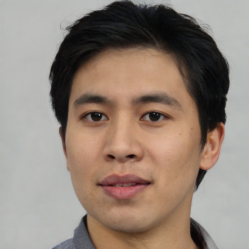 Joyful asian young-adult male with short  black hair and brown eyes