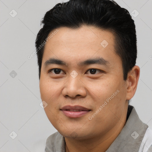 Joyful asian young-adult male with short  black hair and brown eyes