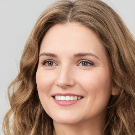 Joyful white young-adult female with long  brown hair and green eyes