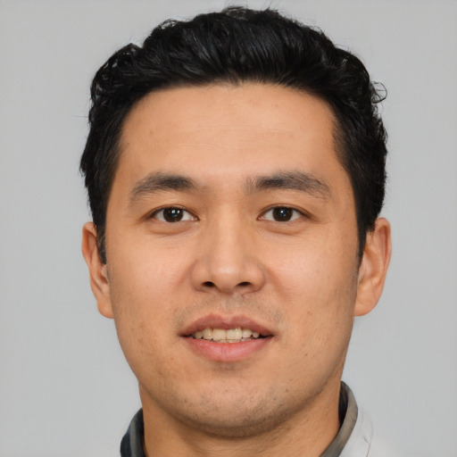 Joyful asian young-adult male with short  black hair and brown eyes