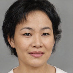 Joyful asian adult female with medium  brown hair and brown eyes