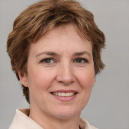 Joyful white adult female with medium  brown hair and grey eyes