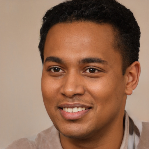 Joyful black young-adult male with short  brown hair and brown eyes