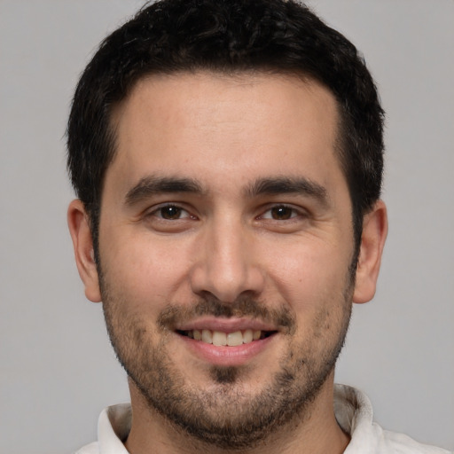 Joyful white young-adult male with short  black hair and brown eyes