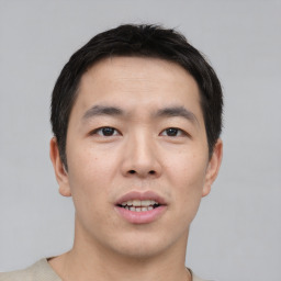 Joyful asian young-adult male with short  black hair and brown eyes