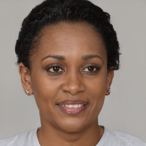 Joyful black adult female with short  brown hair and brown eyes