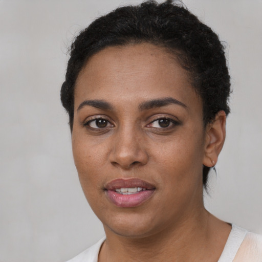 Joyful black young-adult female with short  brown hair and brown eyes