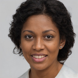 Joyful black young-adult female with long  brown hair and brown eyes