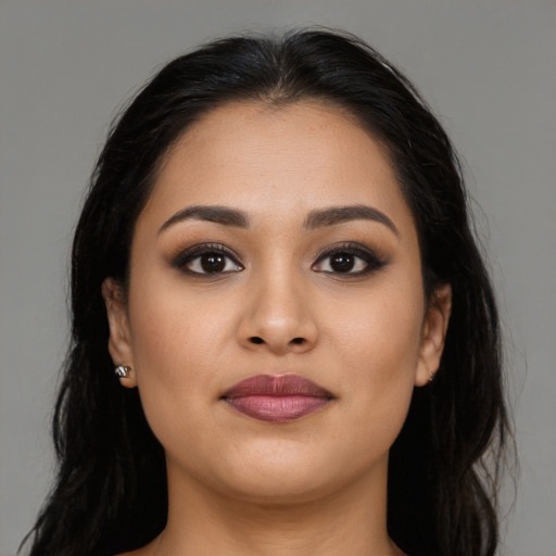 Joyful latino young-adult female with long  brown hair and brown eyes