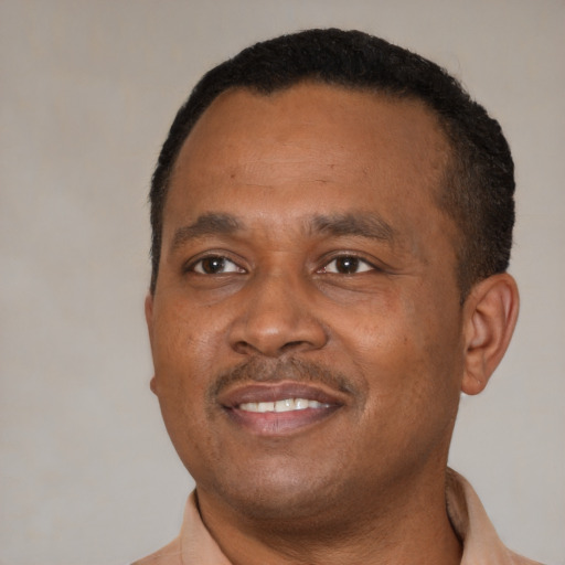 Joyful black adult male with short  brown hair and brown eyes