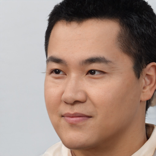 Joyful asian young-adult male with short  brown hair and brown eyes