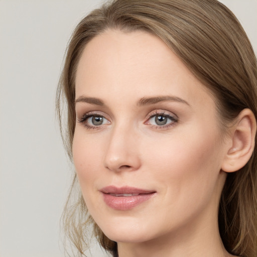 Joyful white young-adult female with long  brown hair and blue eyes