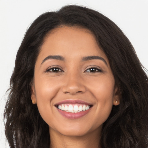 Joyful latino young-adult female with long  brown hair and brown eyes