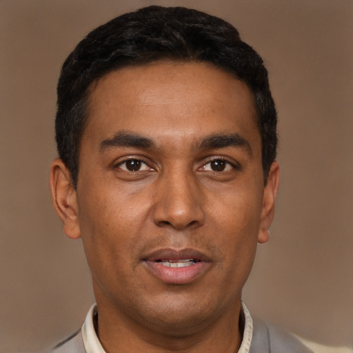 Joyful black young-adult male with short  brown hair and brown eyes