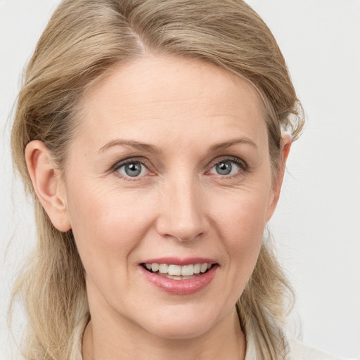 Joyful white adult female with medium  brown hair and blue eyes