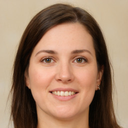 Joyful white young-adult female with long  brown hair and grey eyes