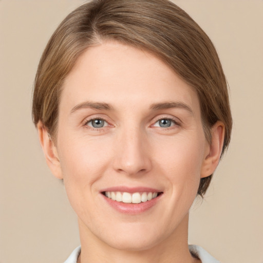 Joyful white young-adult female with short  brown hair and green eyes