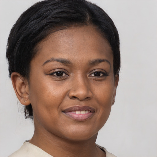 Joyful black young-adult female with short  brown hair and brown eyes